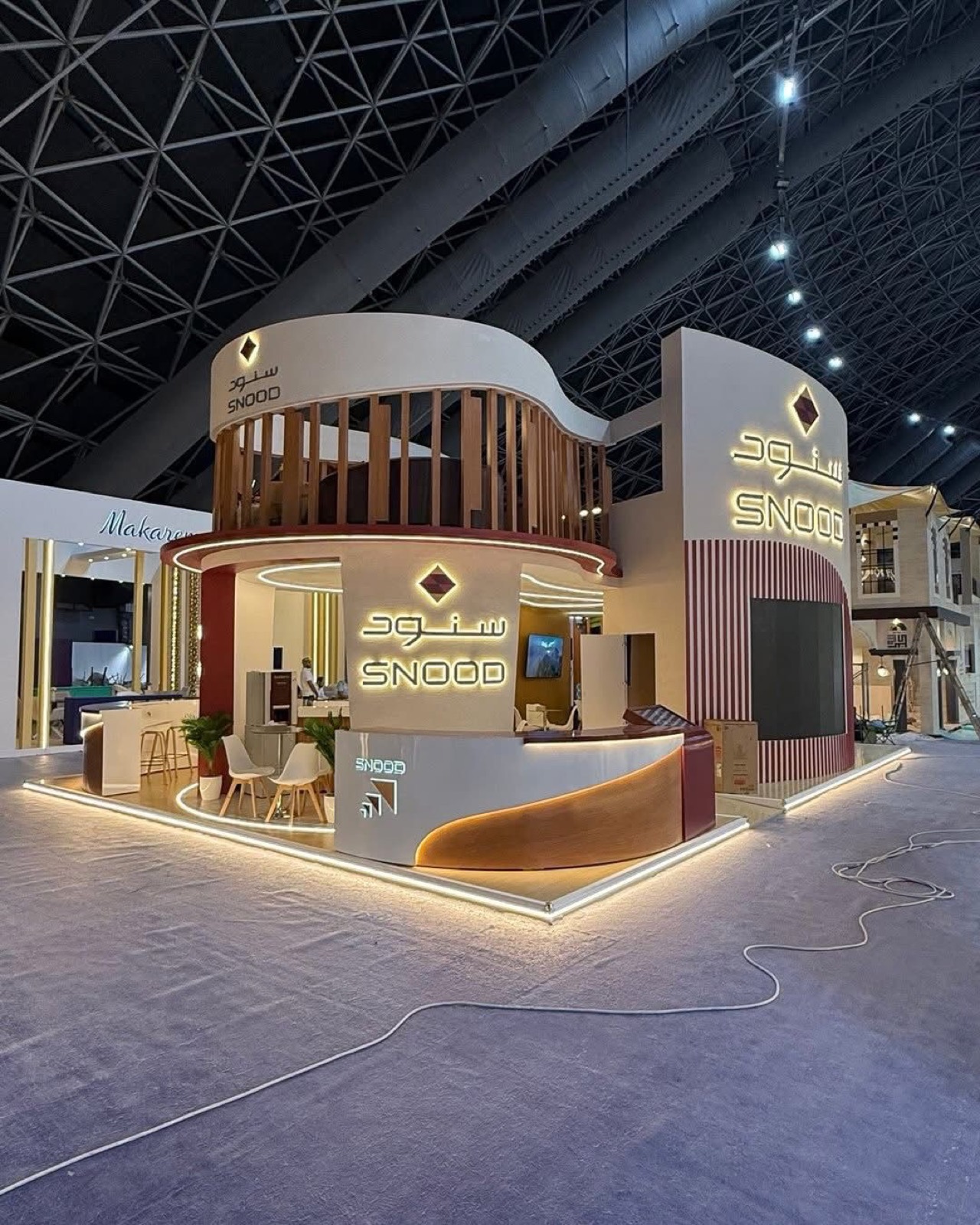 Snood Hotels exhibition booth with fabricated curved walls and lit Arabic signage.